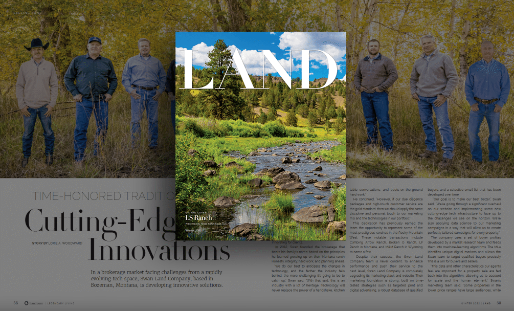 A magazine page features a cover image of a scenic river and trees overlaid on an article about land for sale. In the background, five men stand outdoors among autumn leaves, dressed in jeans and jackets, suggesting a classic cattle ranch setting.