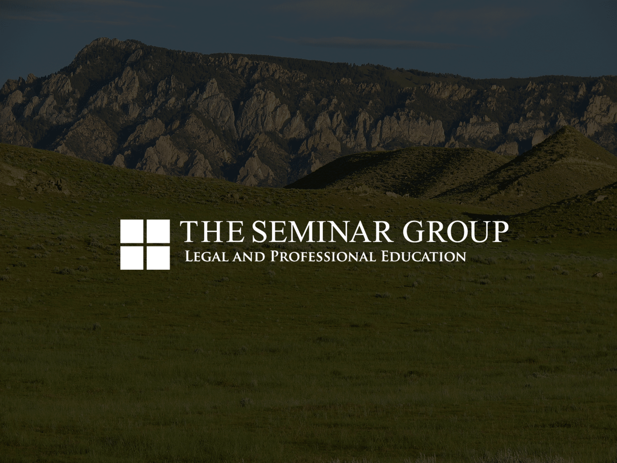 Logo for The Seminar Group, Legal and Professional Education, displayed over a grassy landscape with rolling hills reminiscent of a cattle ranch and distant rocky mountains under a partly cloudy sky.