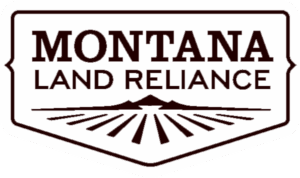 A logo for Montana Land Reliance featuring bold text above a graphic of distant mountains and stylized farmland rows, highlighting recreational land in a dark, monochrome design on a white background.